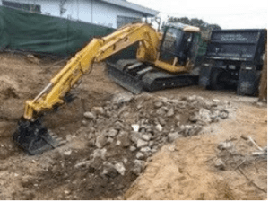 A truck crane digging dirt